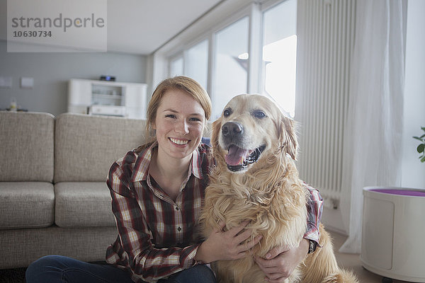Porträt einer lächelnden jungen Frau mit ihrem Hund