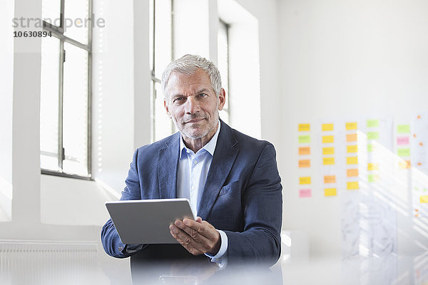 Porträt eines Geschäftsmannes im Büro mit digitalem Tablett