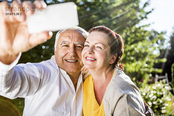 Ein glückliches älteres Paar  das einen Selfie nach draußen bringt.