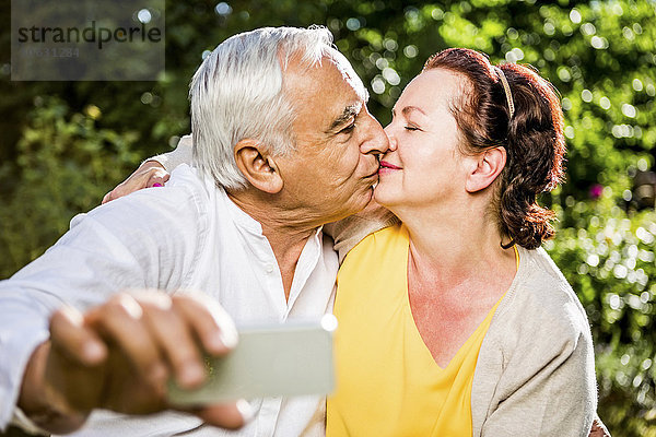 Ältere Paare  die sich küssen und mit sich selbst nach draußen gehen.
