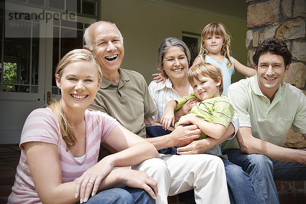 Gruppenbild von drei Generationen Familie auf der Terrasse sitzend
