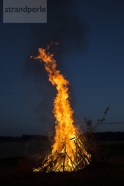 Lagerfeuer auf einer Wiese am Abend