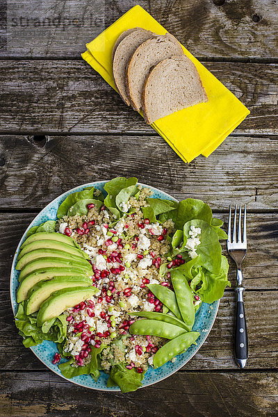 Quinoa-Salat mit Feta  Granatapfel  Avocado und Schnee-Erbsen auf dem Teller