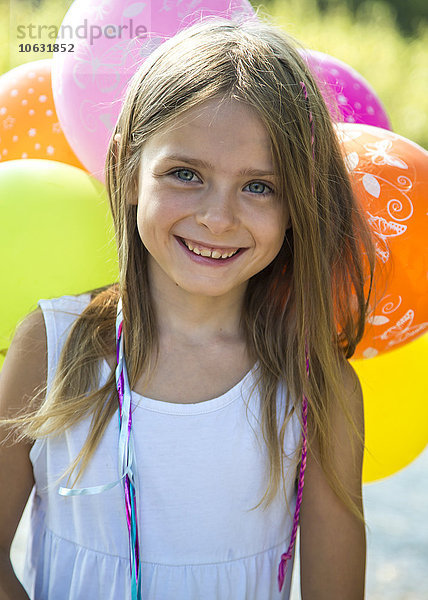 Porträt eines lächelnden Mädchens mit Luftballons