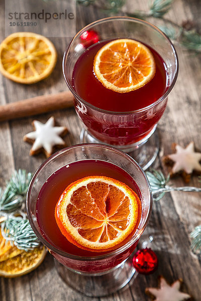 Zwei Gläser Glühwein mit Orangenscheiben zur Weihnachtszeit