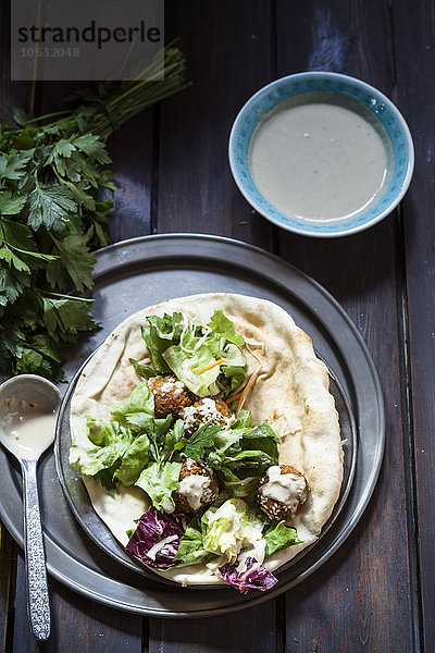 Hausgemachte Falafel mit Salat  Tahinisauce auf Fladenbrot