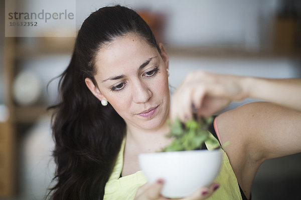 Porträt einer Frau bei der Zubereitung von Salat