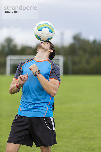 Fußballer balanciert Ball auf Kopf
