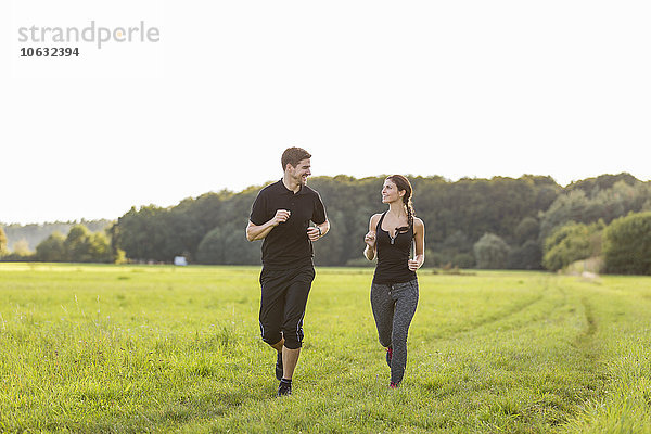 Mann und Frau beim Joggen auf dem Feld