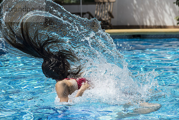 Frau im Poolwasser mit Haareziehen