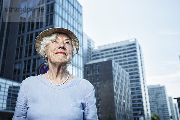 Deutschland  Berlin  Porträt einer lächelnden Seniorin  die sich etwas ansieht