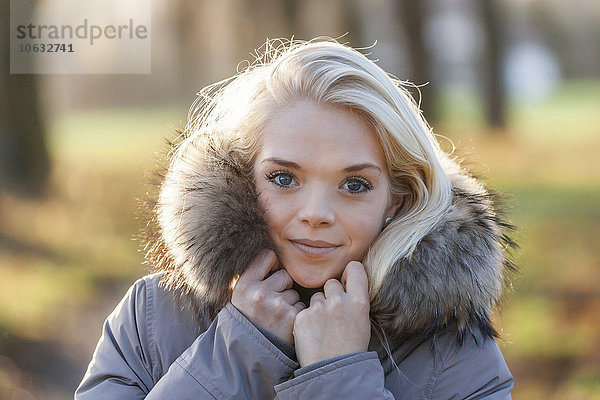 Porträt der lächelnden jungen blonden Frau im Herbst
