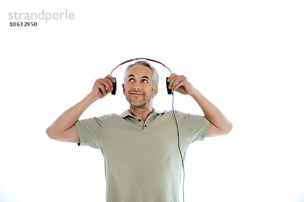 Porträt eines lächelnden Mannes mit Kopfhörern vor weißem Hintergrund