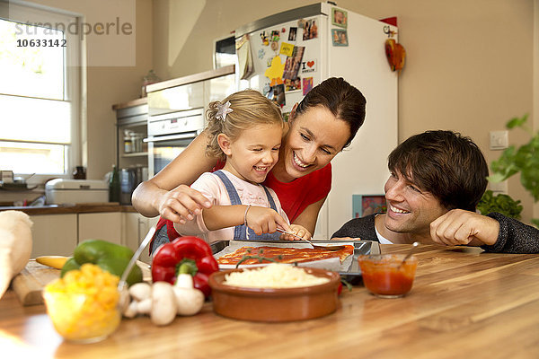 Glückliche Familie in der Küche bei der Zubereitung von Pizza