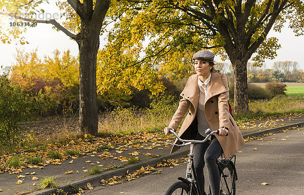 Junge Frau beim Radfahren in der Herbstlandschaft