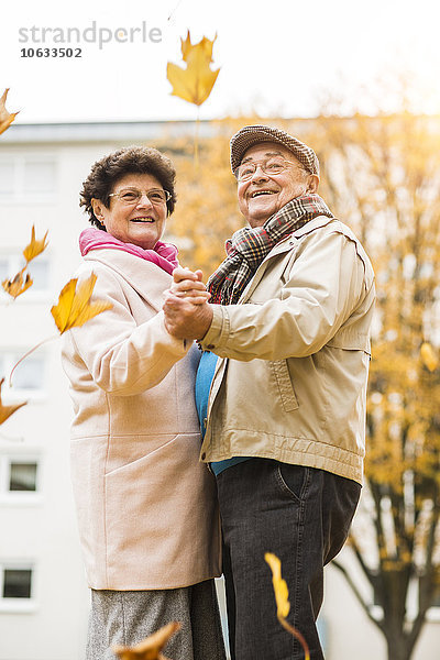 Fröhliches Seniorenpaar tanzt im Herbst im Freien