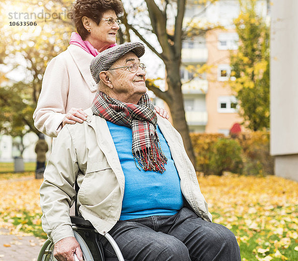 Seniorin mit Ehemann im Rollstuhl im Freien