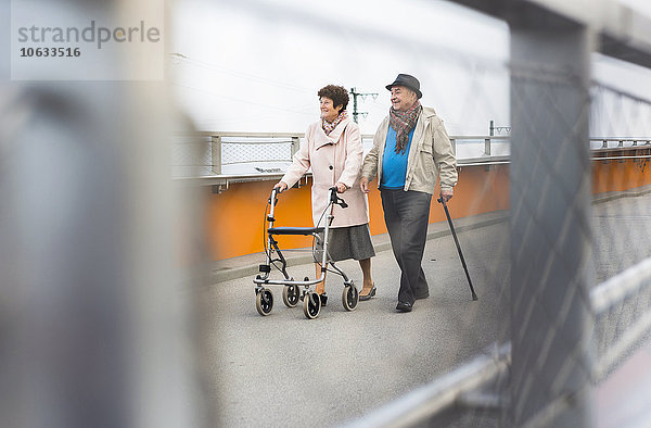 Seniorenpaar mit Spazierstock und Rollator