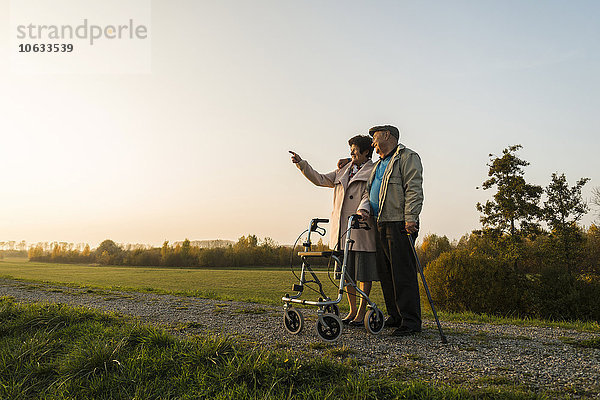 Seniorenpaar mit Spazierstock und Radwanderer in der Natur stehend