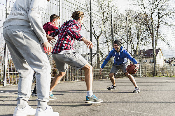 Junge Männer spielen Basketball