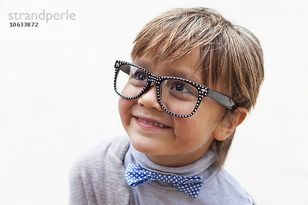 Porträt des lächelnden kleinen Jungen mit Fliege und übergroßer Brille