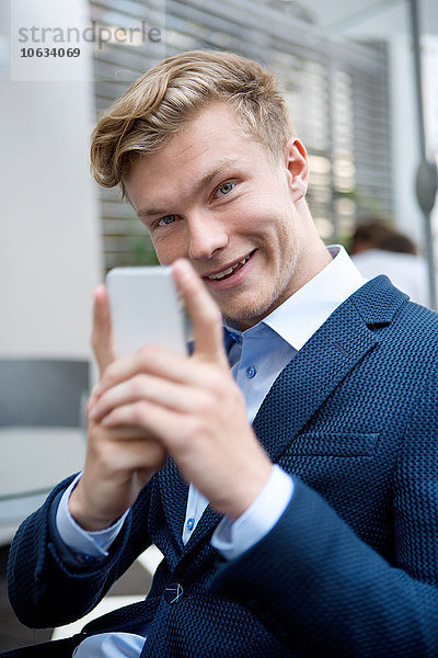 Portrait eines jungen Geschäftsmannes mit Handy