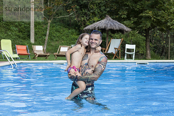 Spanien  Girona  tätowierter Mann mit seiner Tochter im Schwimmbad