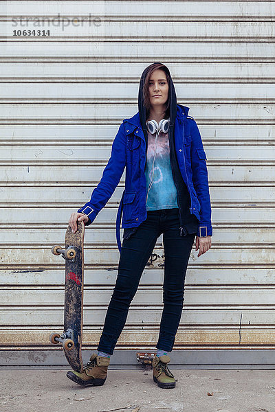 Portrait einer jungen Frau mit Skateboard