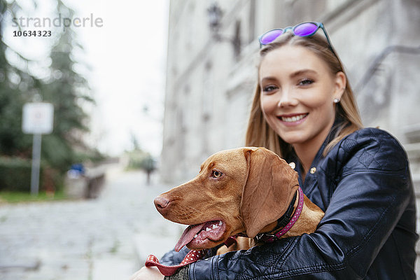 Serbien  Petrovaradin  lächelnde junge Frau mit Hund im Arm