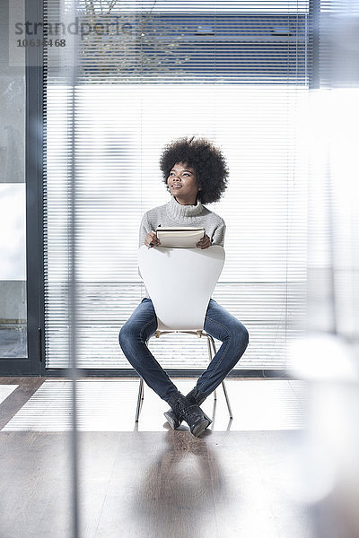 Frau auf einem Stuhl im Büro sitzend  denkend