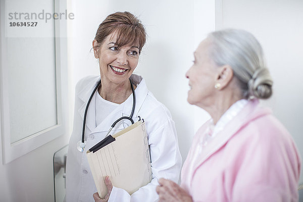 Lächelnder Arzt und älterer Patient im Krankenhaus