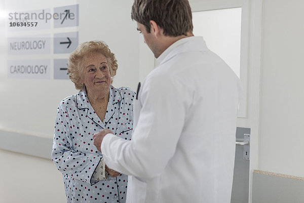 Arzt mit älteren Patienten auf dem Krankenhausboden