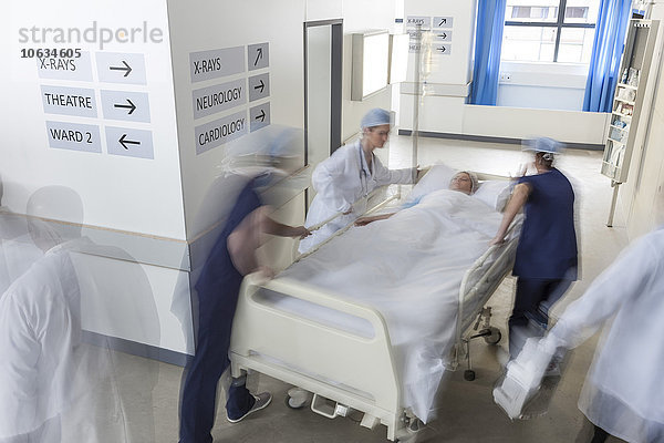 Ärzte schieben ein Bett mit Patienten
