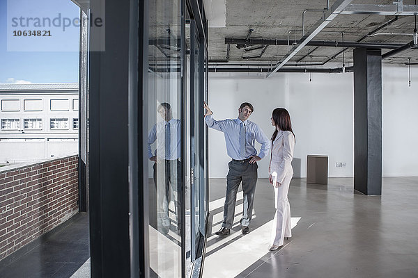 Geschäftsleute stehen am Fenster in neuem offenen Büro