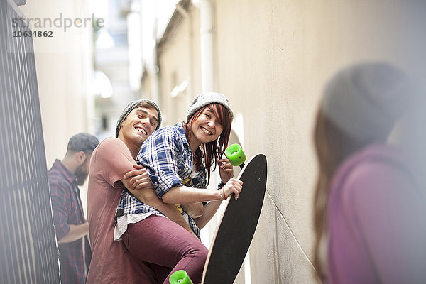 Freunde mit Skateboard haben Spaß in einem Durchgang