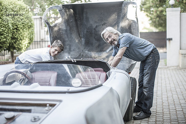 Großvater und Enkel restaurieren gemeinsam ein Auto