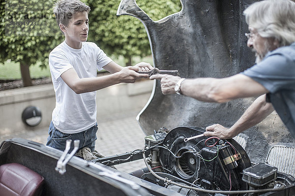Großvater und Enkel restaurieren gemeinsam ein Auto