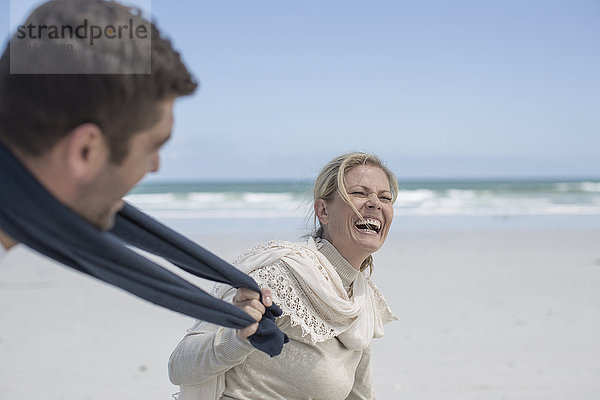 Porträt einer lachenden Frau mit Spaß am Strand