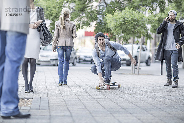 Junger Mann beim Skateboarden auf der Straße