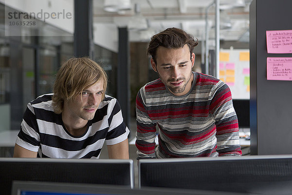 Zwei Männer bei der Arbeit am Computer im Büro