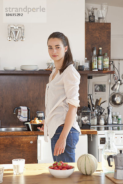 Junge Frau in der Küche stehend  Porträt