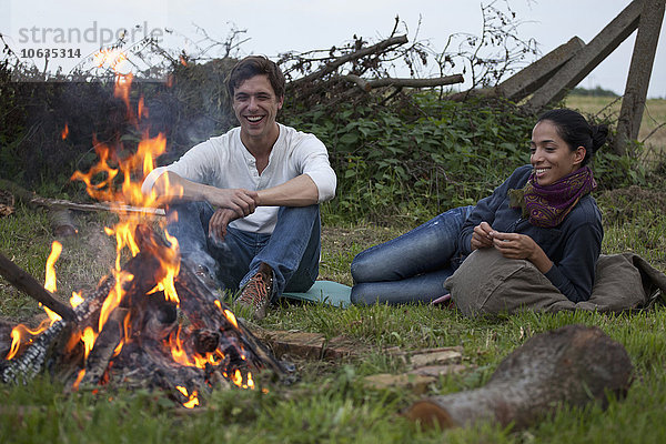 Junges Paar am Lagerfeuer sitzend