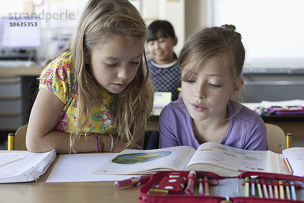 Mädchen lesen Buch im Klassenzimmer