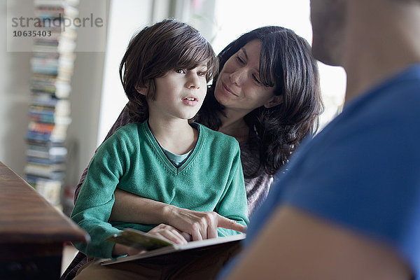 Mutter erklärt dem Sohn beim Lesen des Buches