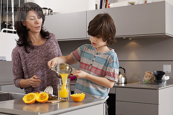 Mutter und Sohn machen Orangensaft