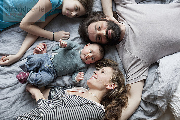 Hochwinkelansicht der Familie  die sich auf dem Bett ausruht