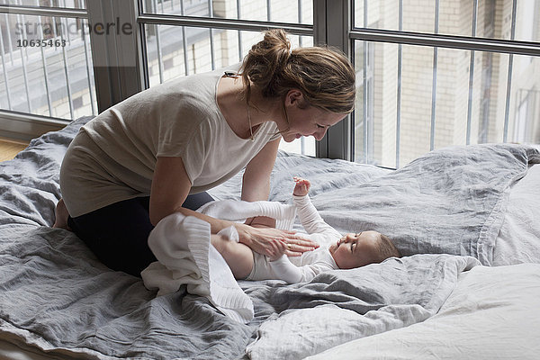 Mutter spielt mit dem Mädchen im Schlafzimmer