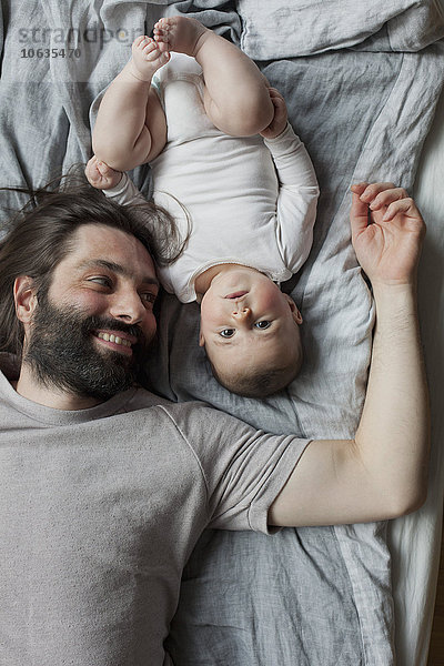 Direkt über der Aufnahme von Vater und Mädchen  die im Bett liegen.