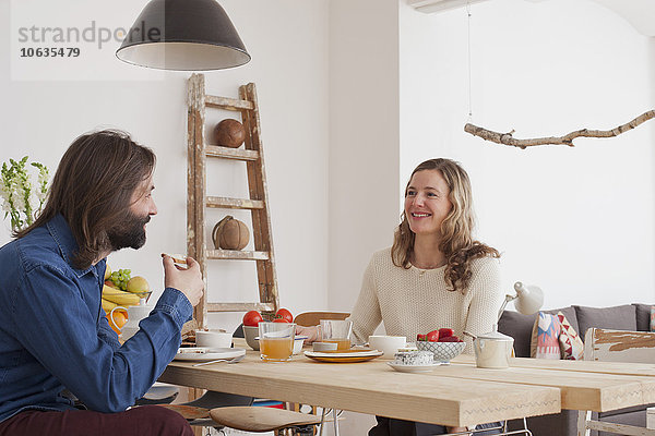 Lächelndes Paar beim Frühstück zu Hause