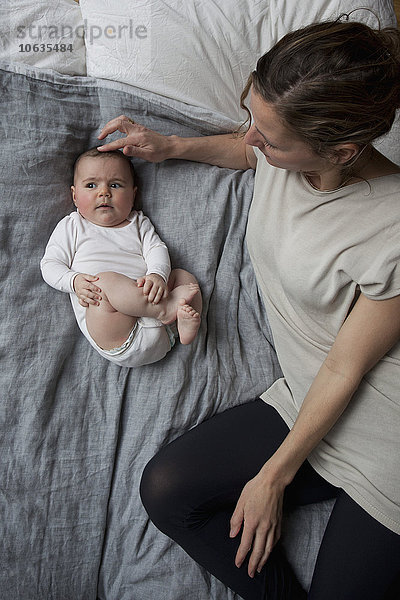 Hochwinkelansicht von Mutter und Baby im Bett